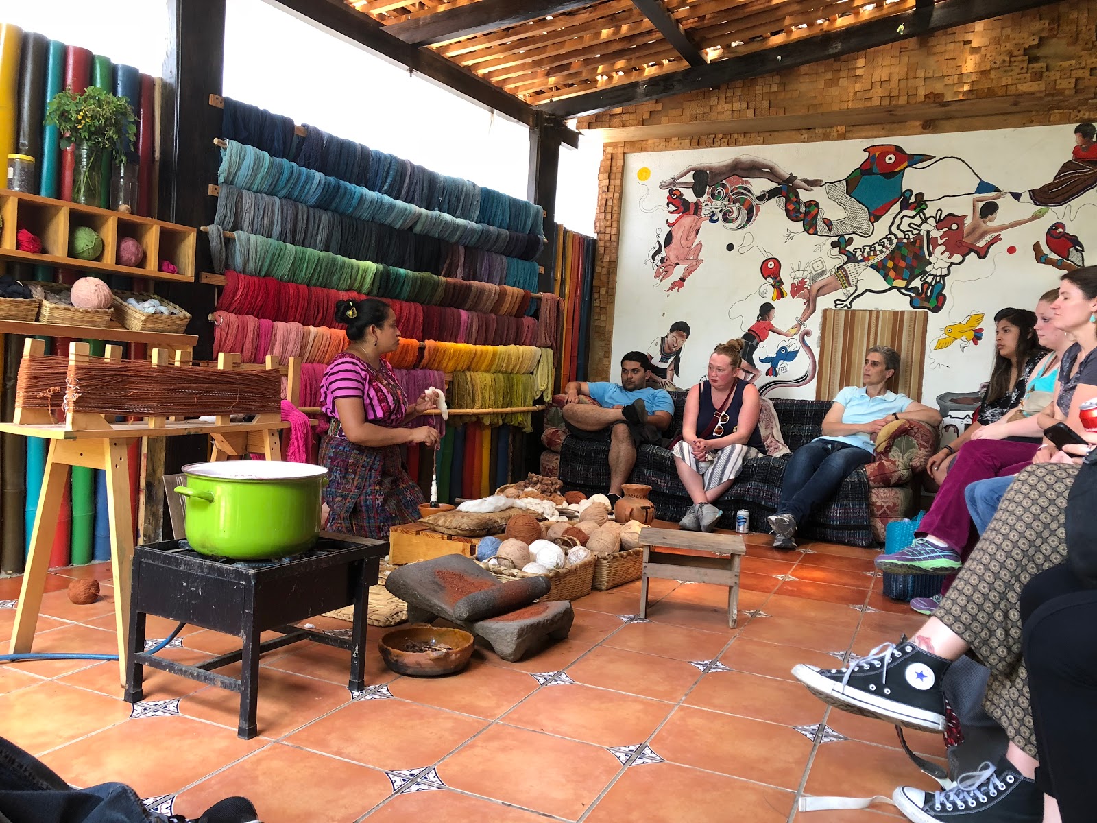 Study abroad participants listening to weaving demonstration